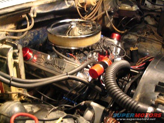 Close-up of a V8 engine with chrome valve covers that say "Ford Racing"