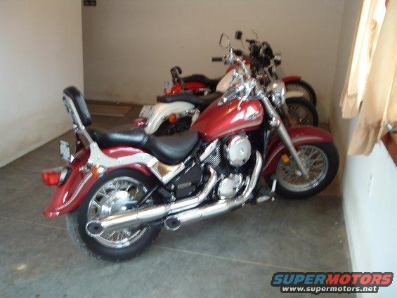 Two motorcycles parked indoors, one red and one white and red