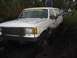 1989 Ford Bronco - This muddy white SUV is stuck in a swampy area with people around.