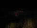 1989 Ford Bronco - Pickup truck is seen from the rear at night, with only its taillight illuminated.