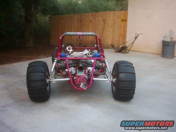 Pink dune buggy with large rear tires and exposed engine