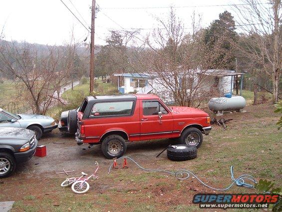 Red 1987 Ford Bronco with black top, spare tire mounted on rear door
