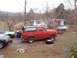 1987 Ford Bronco - A red 1987 Ford Bronco with a black top is parked outdoors, with a spare tire and jack nearby.