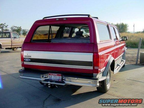 Red Ford Bronco rear view, chrome bumper, silver stripe, roof rack, license plate 6B 15118