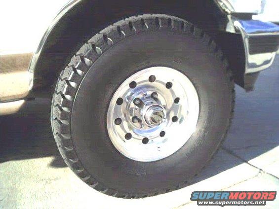 Close-up of a vehicle's front wheel and tire with a chrome rim