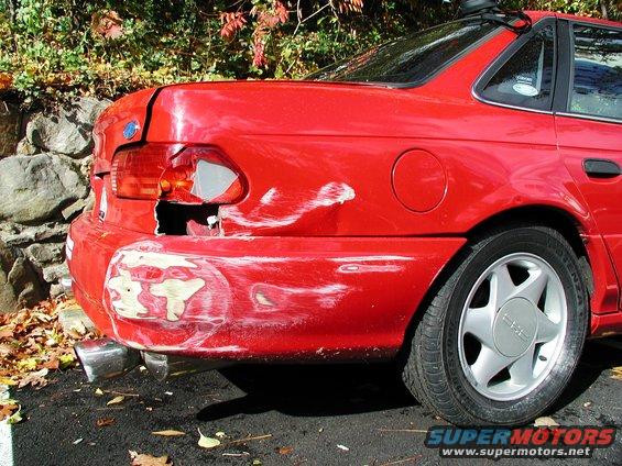 Red 1992 Ford Taurus rear bumper damaged, taillight broken