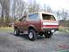 1991 Ford Bronco - This 1991 Ford Bronco has a two-tone paint scheme with a tan top and a red and white stripe on the tailgate.