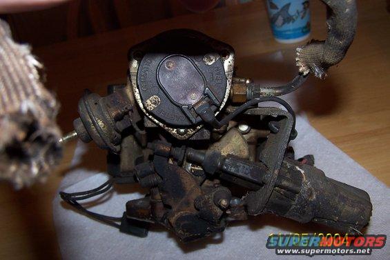 Close-up of a carburetor with visible text on its cap