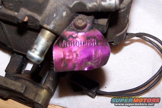 Motorcraft carburetor tag with purple tint and stamped numbers