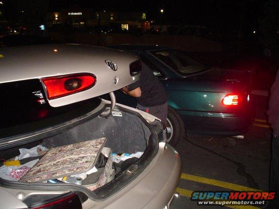 1998 Mercury Sable rear with open trunk and a green sedan beside it