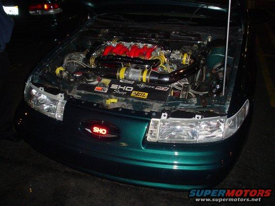 Green car engine bay with SHO badge and red intake manifold