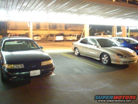 1998 Mercury Sable parked next to a black sedan under a covered lot