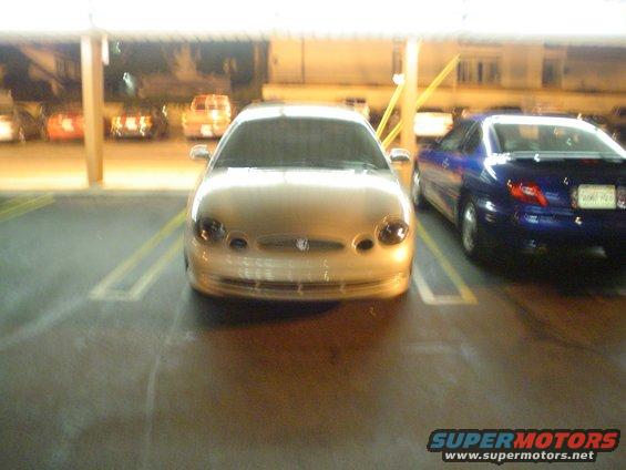 Front view of a gold Ford Taurus parked next to a blue car
