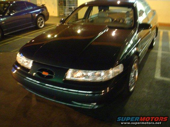 Dark green 1998 Mercury Sable sedan, 3q front view. Another car is parked to the left