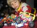 1986 Ford Bronco - A young child is engrossed in playing with a collection of toy monster trucks.