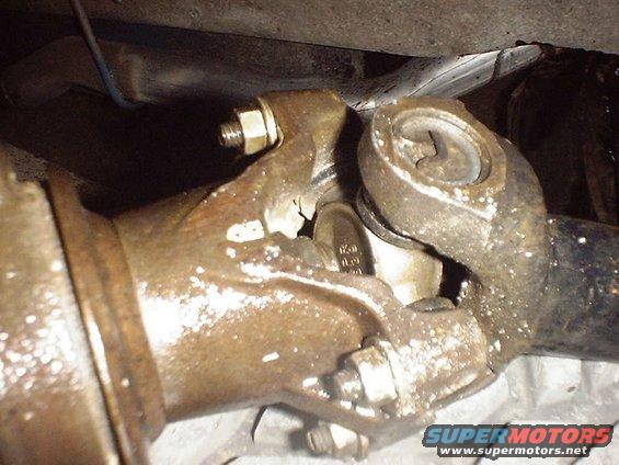 Close-up of a driveshaft U-joint with visible grease and wear