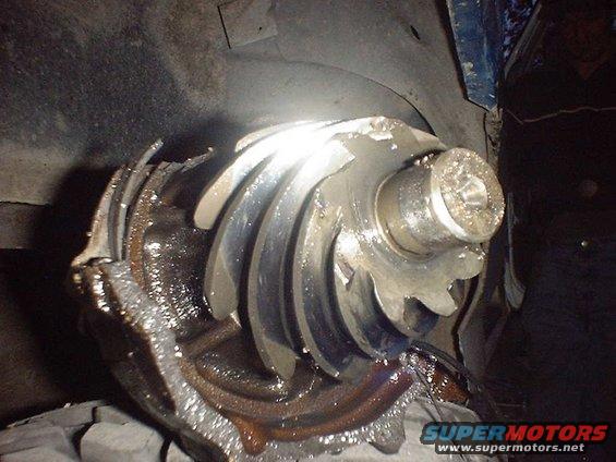 Damaged differential gear with broken teeth, covered in grease