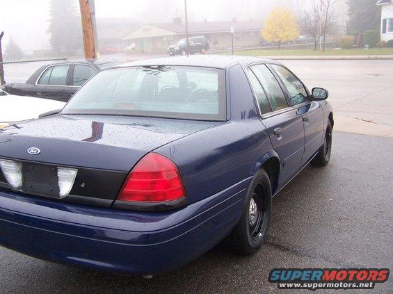 Blue 2001 Ford Crown Victoria sedan, rear quarter view. Another car is parked behind it