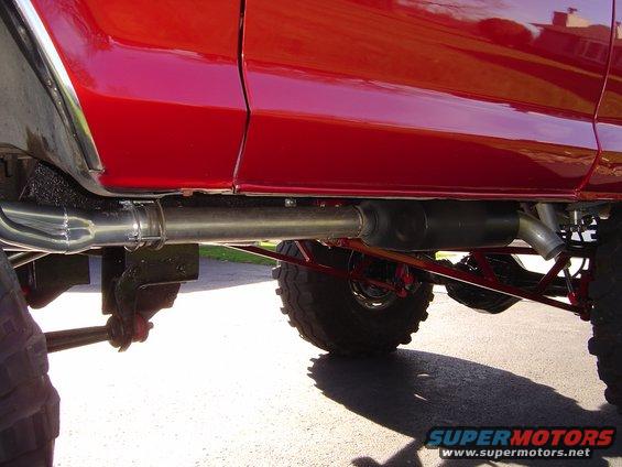 Red vehicle's custom exhaust system and suspension components