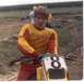 2000 Ford Mustang - A young person in racing gear stands with a dirt bike at a track.