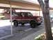 1989 Ford Bronco - A red 1989 Ford Bronco, likely modified with a 2 1/2 inch lift, is seen parked under a carport.