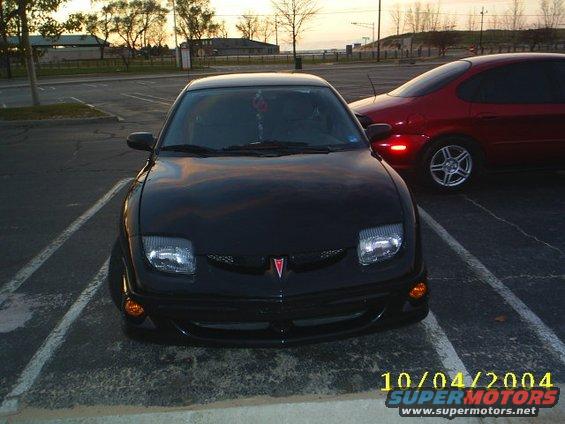 Front view of a black Pontiac Sunfire parked next to a red car