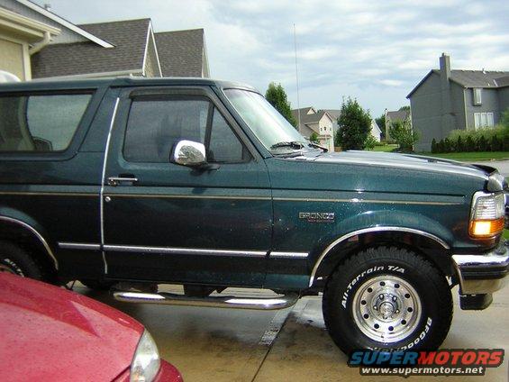 1995 Ford Bronco side profile, dark green paint, chrome trim, aftermarket wheels and tires
