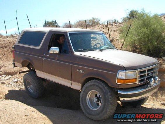 Brown 1993 Ford Bronco with lifted suspension off-roading