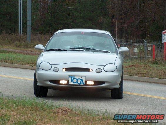 Silver sedan, front view, with a TCCA license plate and aftermarket fog lights
