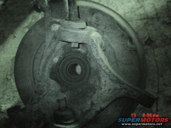 Close-up of a rusty truck front wheel hub assembly with a bearing visible