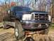 1963 Ford Fairlane - This lifted Ford F-250 Super Duty truck is shown from a three-quarter front view on a gravel surface.