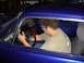 1965 Ford Mustang - A man adjusts the steering wheel inside a custom 1965 Ford Mustang, with aftermarket gauges on the dashboard.