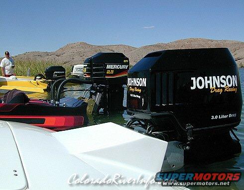 Several boat motors are in the water, including Johnson and Mercury brands. One boat is yellow, another is red and black