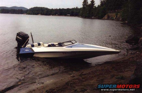 Speedboat pulled up on a rocky shore next to a lake