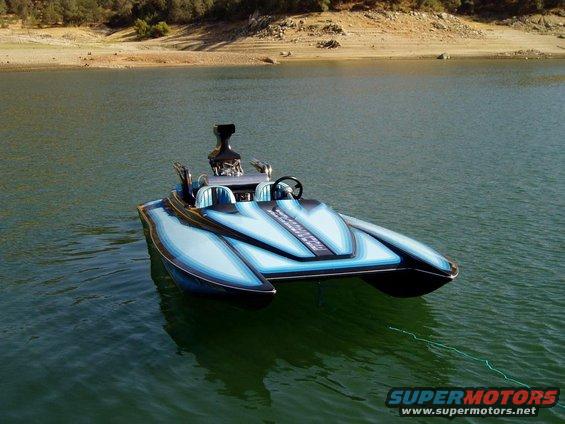 custom blue and black speed boat with exposed engine on water