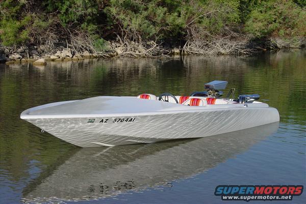 Silver boat with red and white striped interior on water