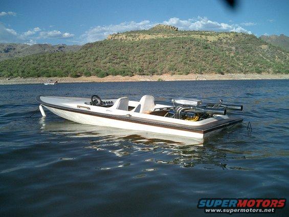 Boat with exposed engine and two seats on the water