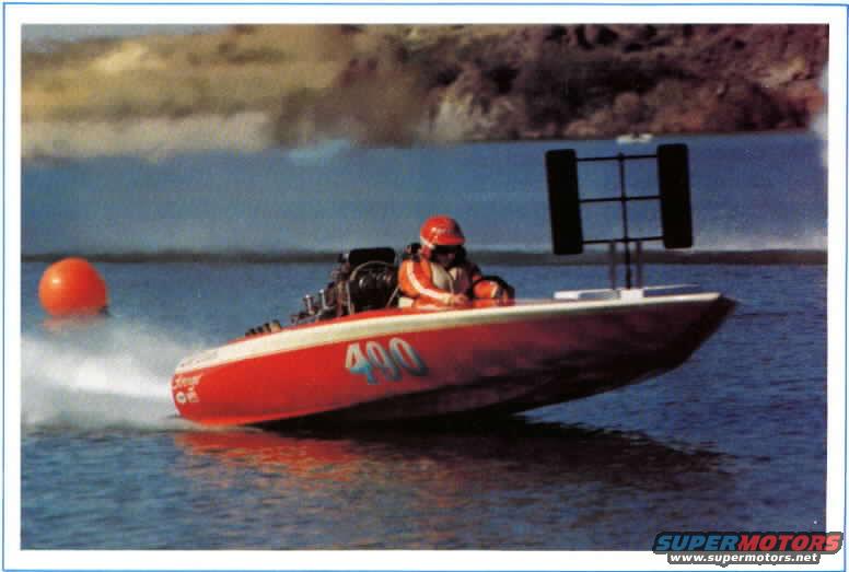 Red and white racing boat with number 400, driver in orange jacket and red helmet, on water