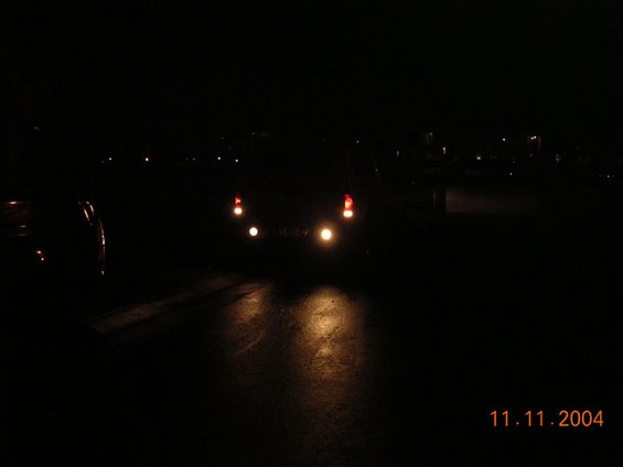Rear lights of a vehicle at night, with date 11.11.2004 visible