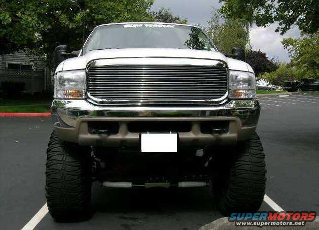 Front view of a white 2000 Ford Excursion with a chrome grille and oversized tires
