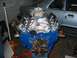 1985 Ford Crown Victoria LTD - A rebuilt V8 engine sits on an engine stand in front of a car.