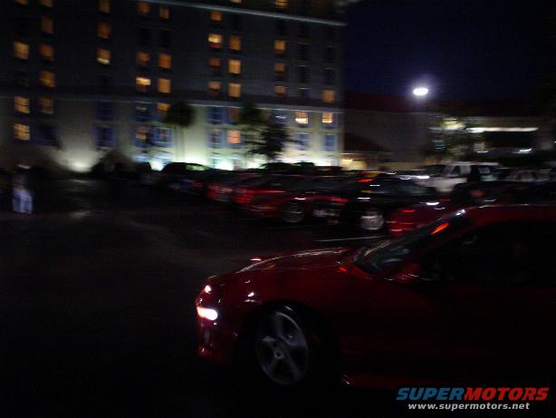 Red car front corner at night, with headlights on