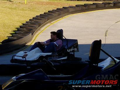 Go-kart with a driver on a track, showing the side view and the number 88 on the side
