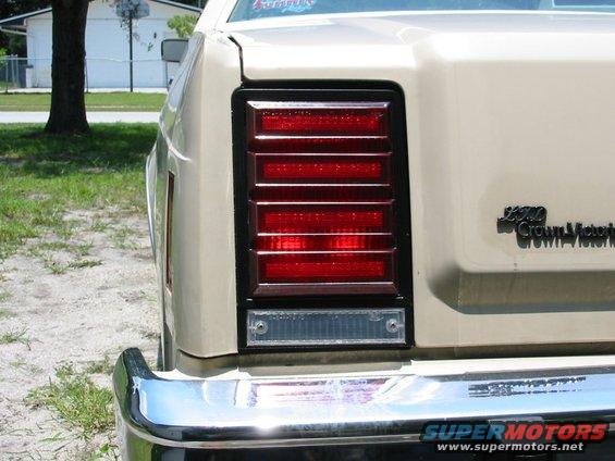 Rear taillight and 'Crown Victoria' badging on a tan car