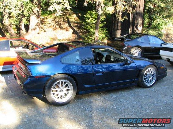 Blue 1986 Pontiac Fiero parked outdoors with other cars visible