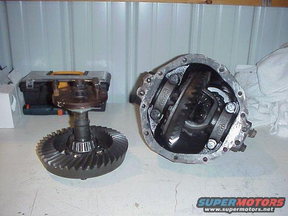 Differential gears and housing laid out on a table. A toolbox is visible in the background