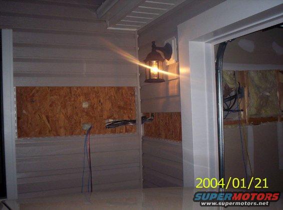 Garage interior with exposed wiring and plywood, dated 2004/01/21