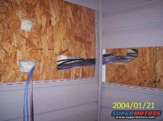 Electrical wires run through holes in OSB wall paneling, with blue and red wires exiting lower left. Date stamp 2004/01/21