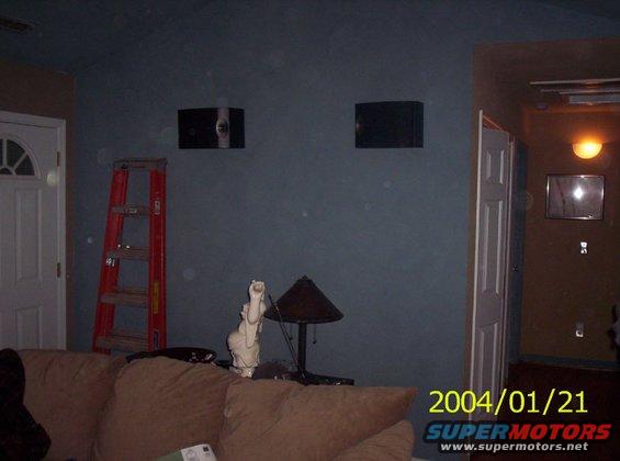Room interior with couch, red ladder, two speakers on wall, and a statue