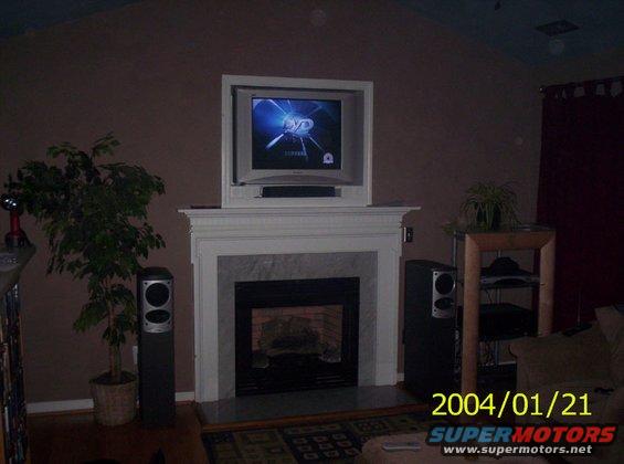 Living room with fireplace, television, speakers, and a potted plant. Date stamp reads 2004/01/21